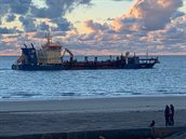 Baggerschip ligt voor de kust om zand te lossen